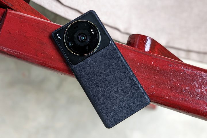Xiaomi 12S Ultra in gray color on a red and white armchair.