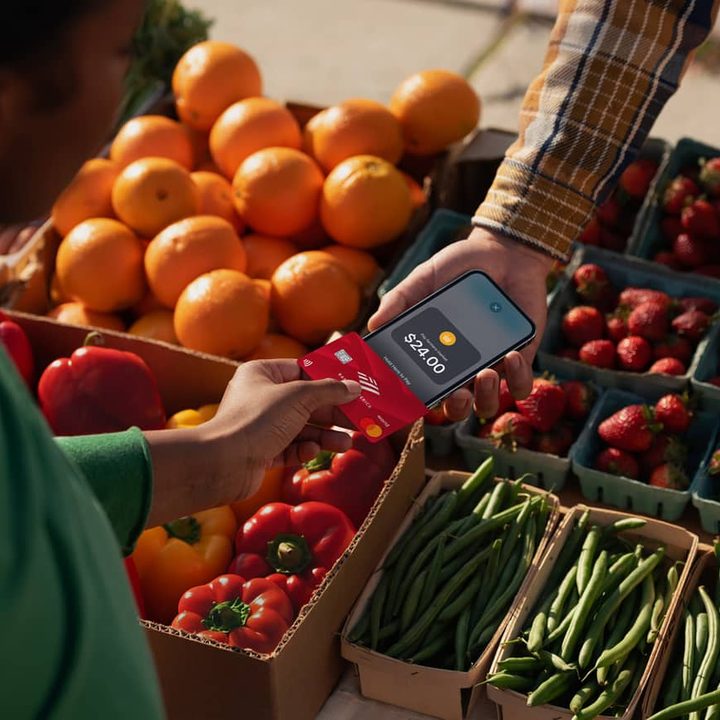 Person tapping a contactless payment card on an iPhone.