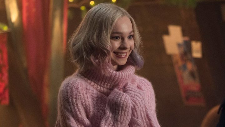Enid smiling widely while pressing her hands to her chest in Wednesday.