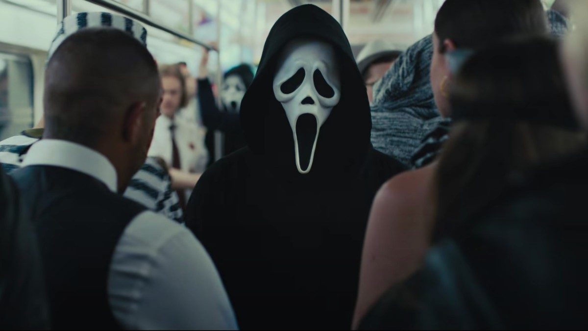 A masked person stands on a subway in Scream VI.