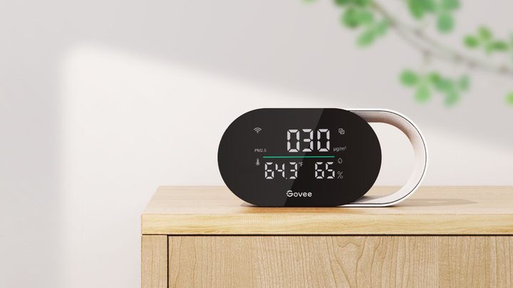 The Govee Smart Air Quality Monitor sitting on a wooden stand.
