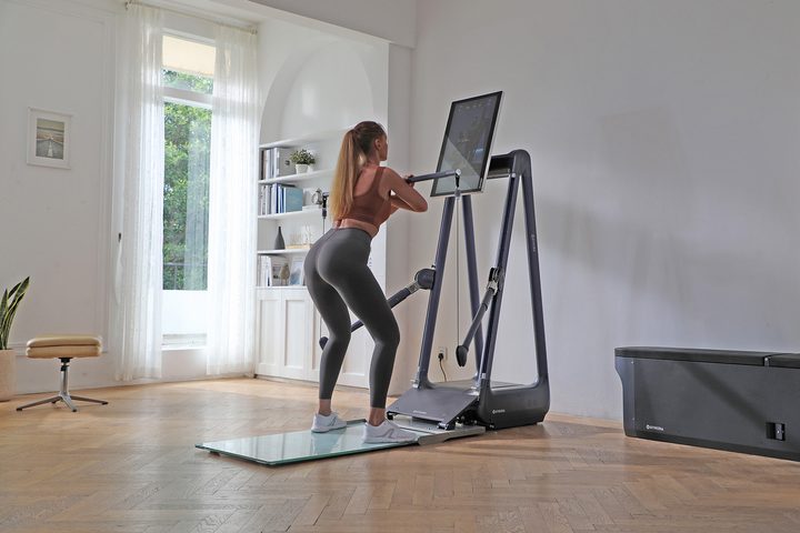 A woman doing front squats with the Gymera Smart Home Gym.