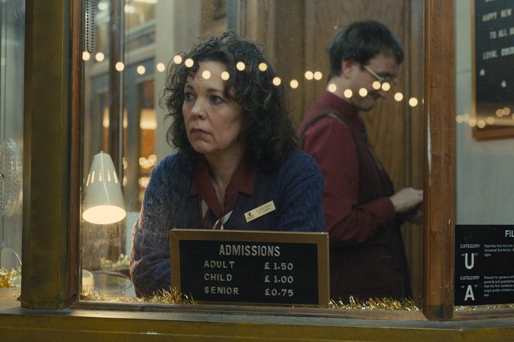 Olivia Colman stands in a ticket booth in Empire of Light.