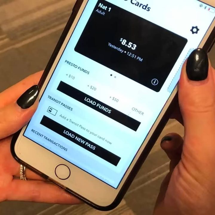 Person holding iPhone with Presto transit fare app open.