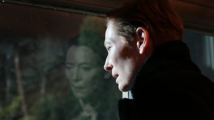 A woman looks out a window in The Eternal Daughter.