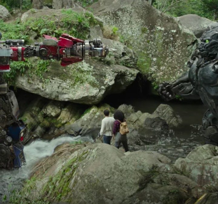 Optimus Prime points a gun at a gorilla in a scene from Transformers Rise of the Beasts.