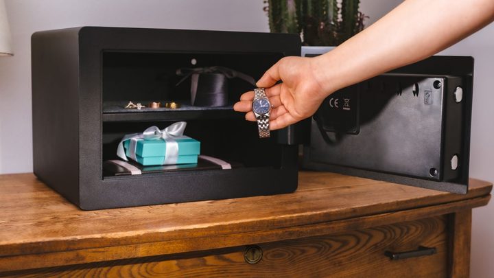 A person putting valuables in the Yale Smart Safe.