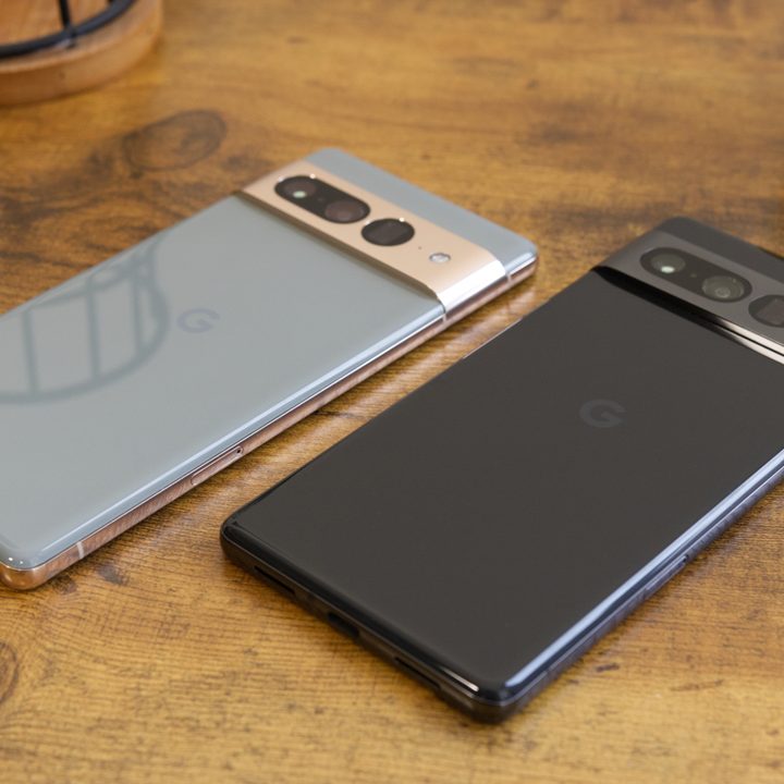 Two Google Pixel 7 Pro smartphones laying on a desk.