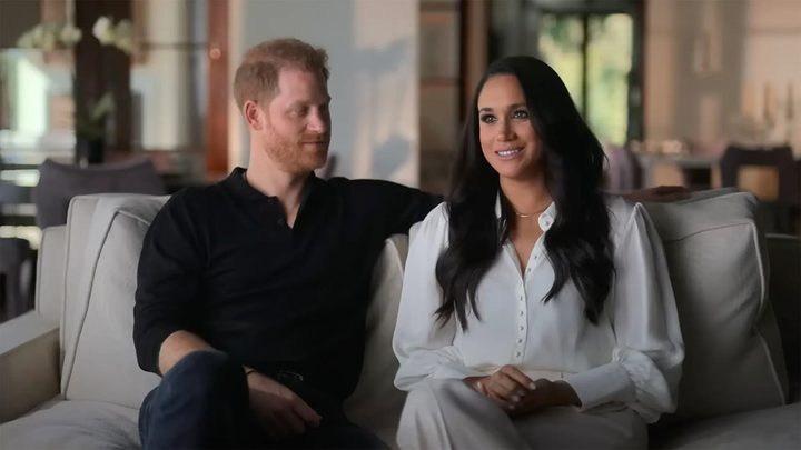 Harry and Meghan sitting on a couch during an interview for Harry & Meghan.