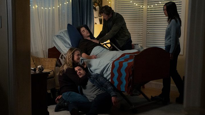 The Stone family surrounding Cal in a hospital bed, a drained Zeke on the floor being cradled by Michaela on Manifest.