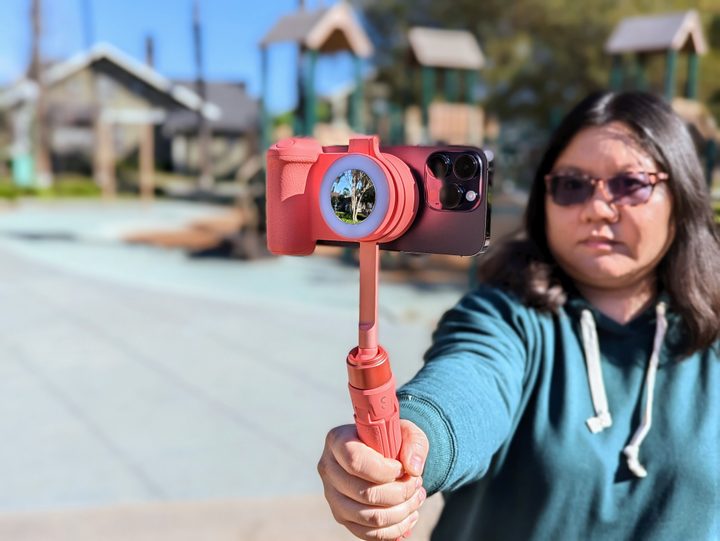 ShiftCam SnapGrip with SnapPod and SnapLight held in hand seen from behind with iPhone 14 Pro