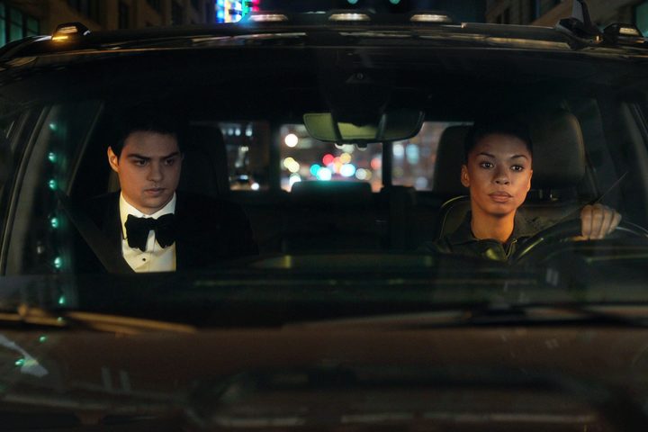 A man and a woman drive a car in The Recruit.
