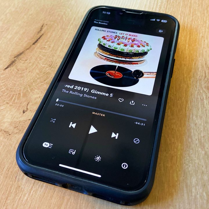 An iPhone with the Rolling Stones playing on the Tidal app.