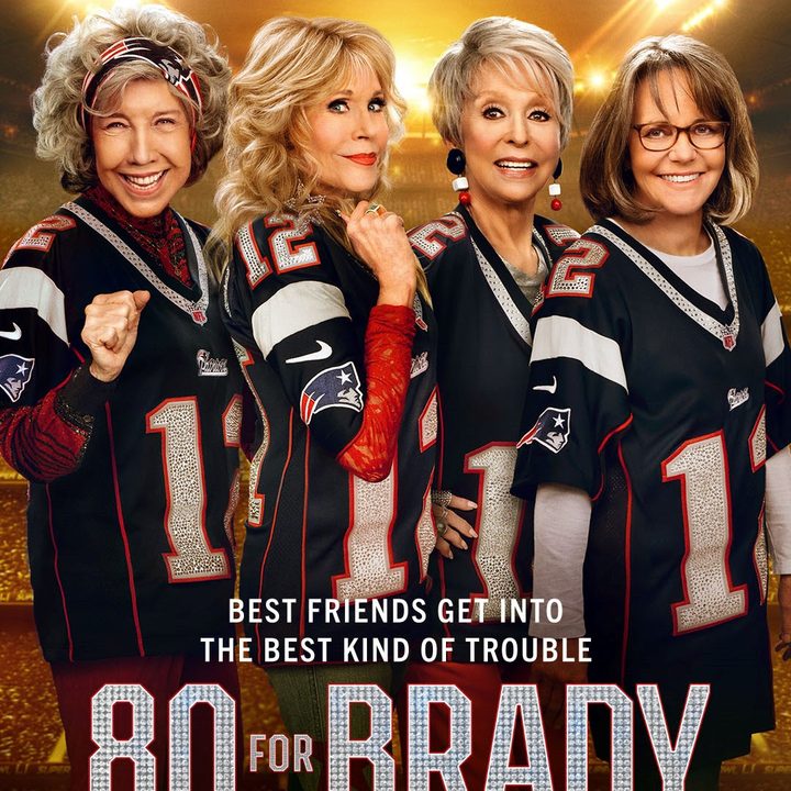 Four women stand next to each other on the 80 for Brady poster.