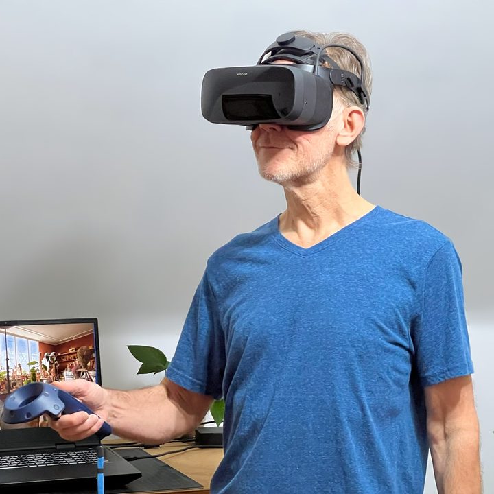 Alan Truly stands in front of a laptop and wears the Varjo Aero VR headset