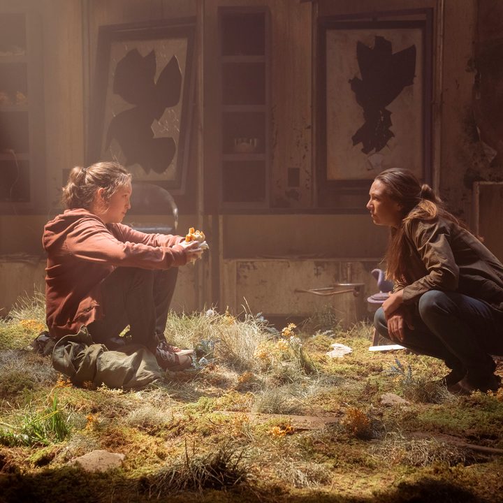 Bella Ramsey sits in front of Anna Torv in The Last of Us.