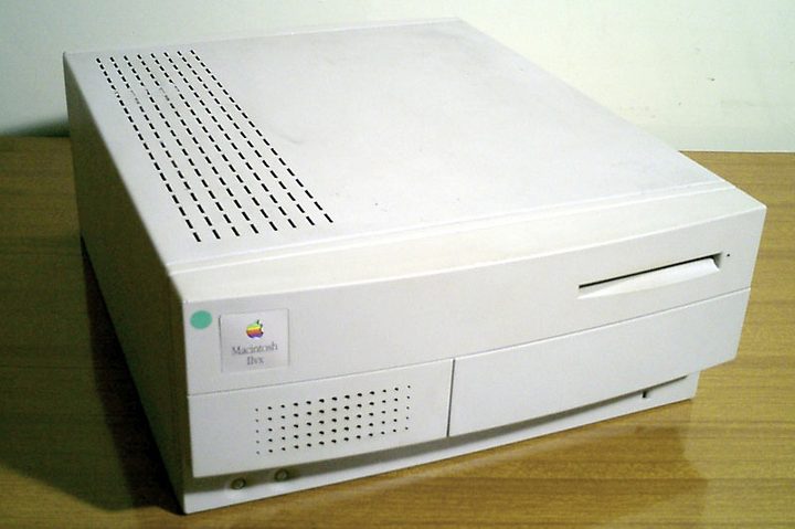 An Apple Macintosh IIvx computer on a wooden desk.