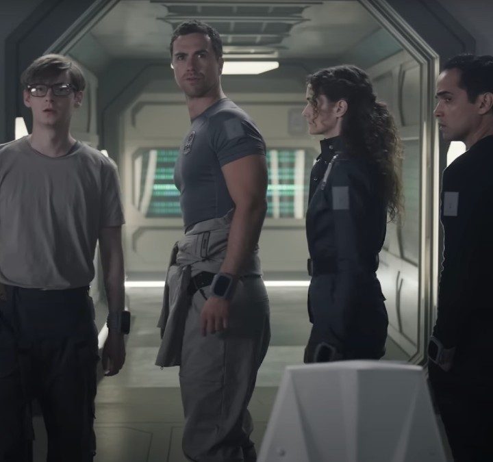 Four people stand next to each other and stare in The Ark.