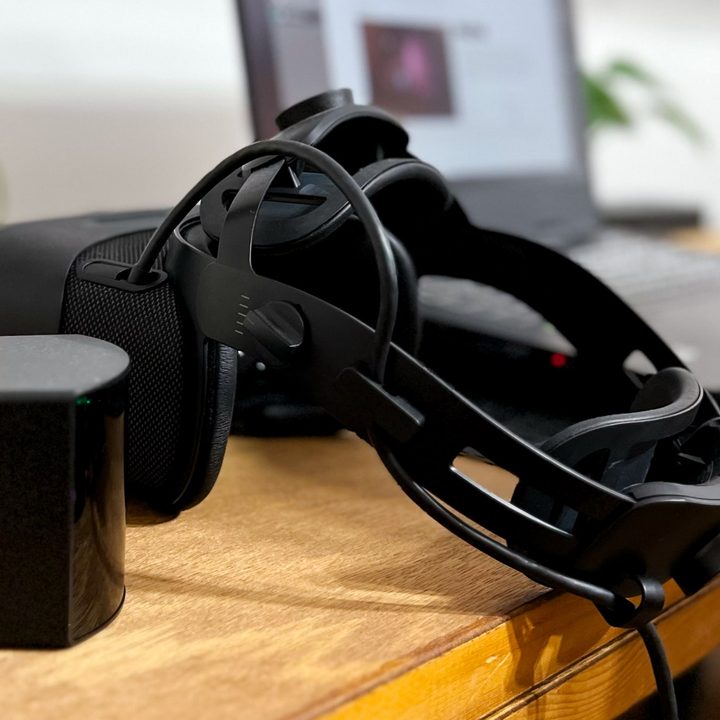 Varjo Aero rests on a desk beside a Steam base station and a laptop.
