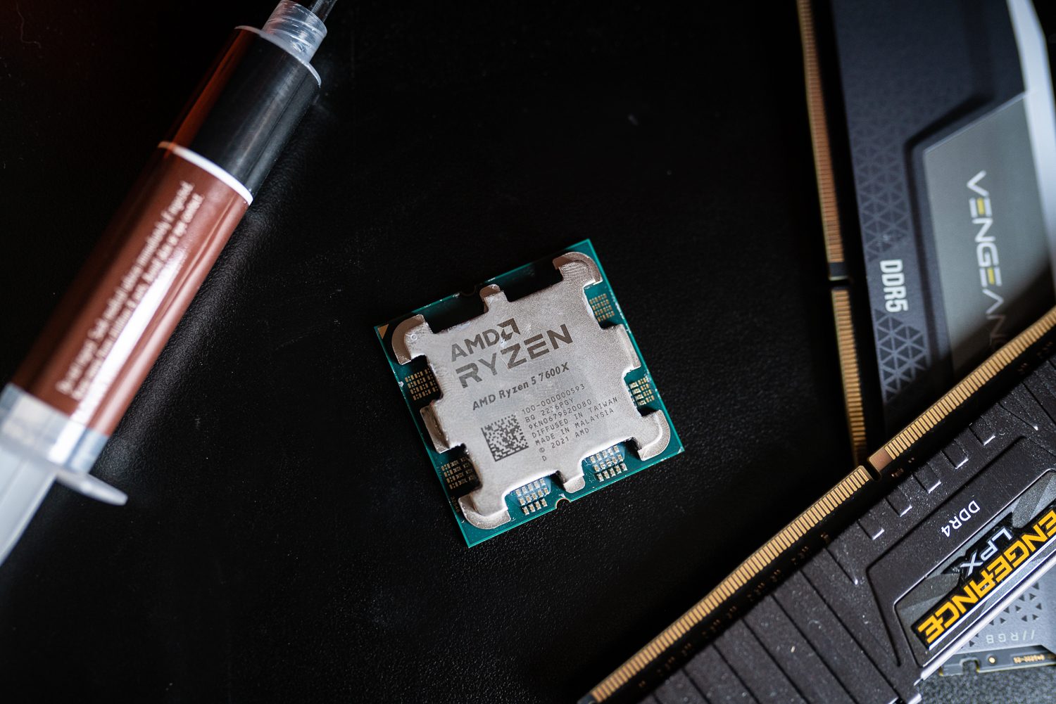 The Ryzen 5 7600X sitting among thermal paste and RAM.
