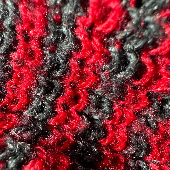 Macro photo of a red and black beanie.