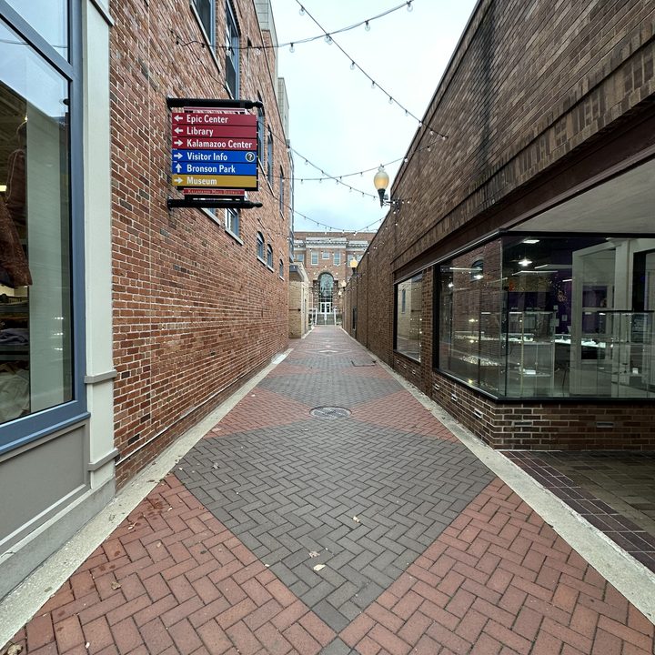Photo of an alley with a brick walkway.