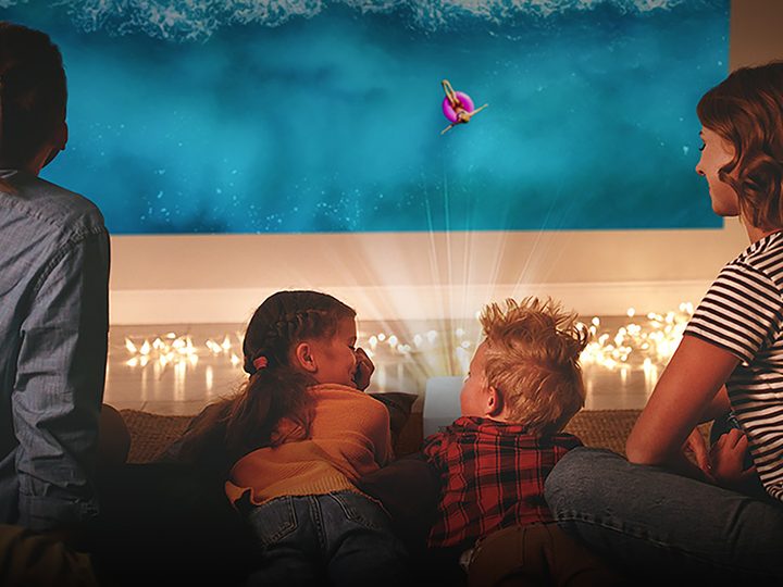 A family watching the LG CineBeam Portable Projector.