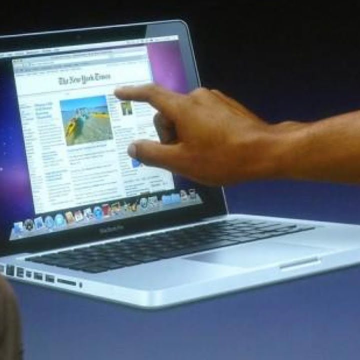 Steve Jobs in front of a graphic of a touchscreen MacBook.