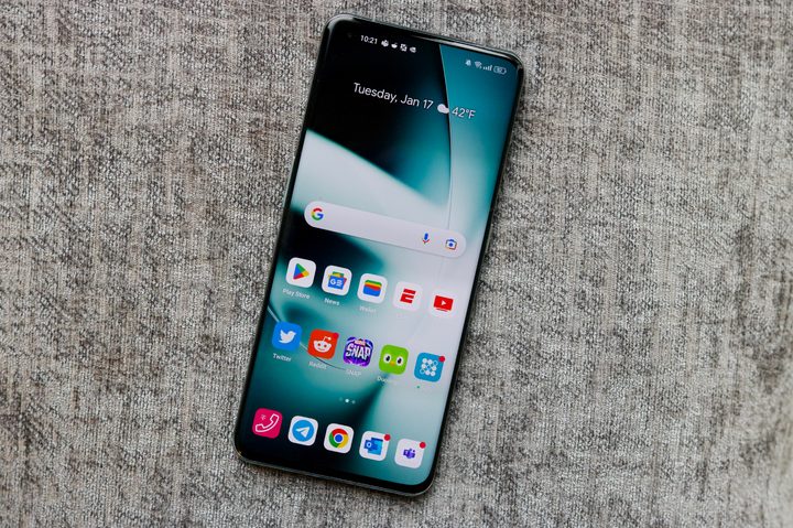 OnePlus 11 lying on a pillow with the screen turned on.