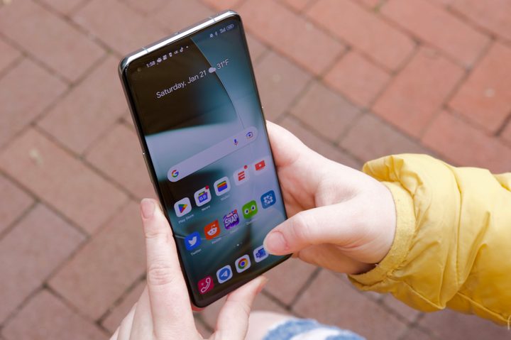 Someone using the OnePlus 11. The display is on and showing the home screen.