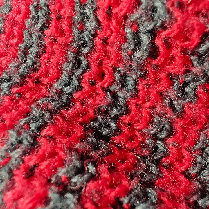 Macro photo of a red and black beanie.