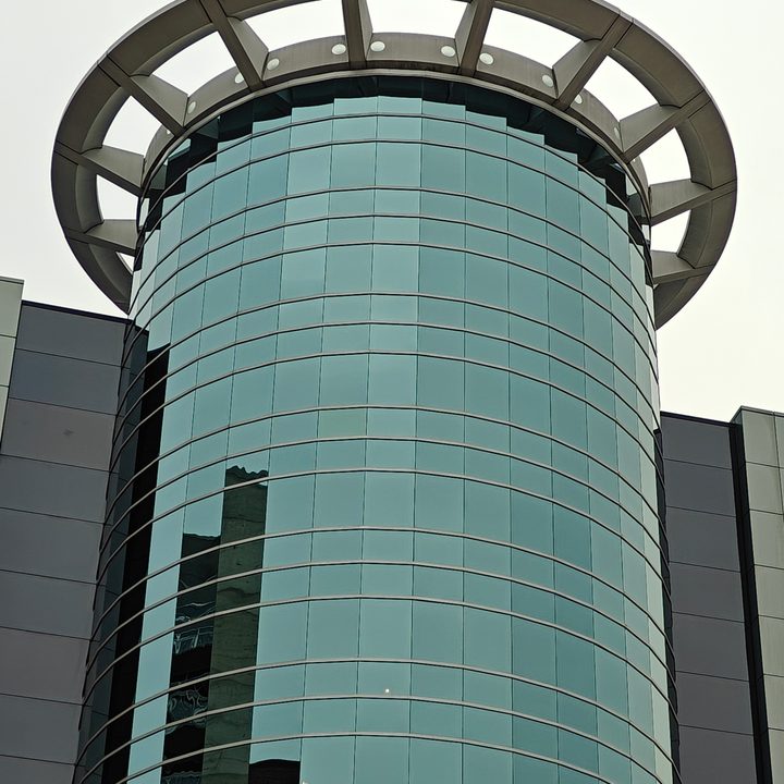 Zoomed in photo of a circular, glass building.