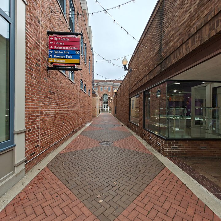 Photo of an alley with a brick walkway.