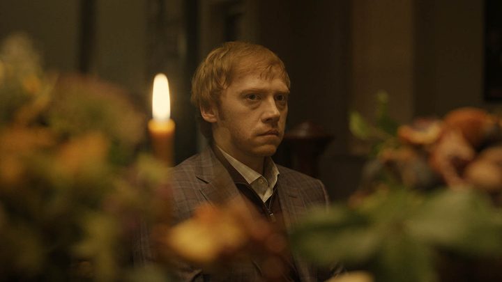 Julian sitting at the dinner table on Servant, flowers and a candle in the foreground.