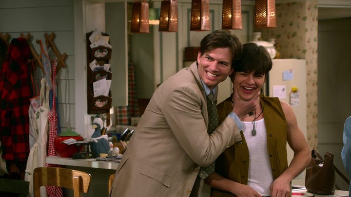 Michael Kelso squeezing his son Jay Kelso's face while both men smile in a scene from That '90s Show.