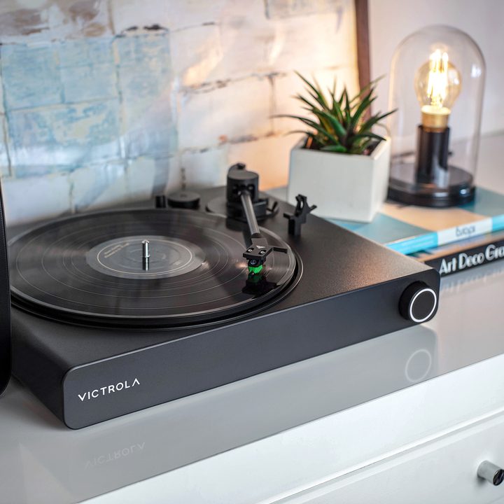The Victrola Stream Onyx Sonos-ready turntable on a white cabinet.