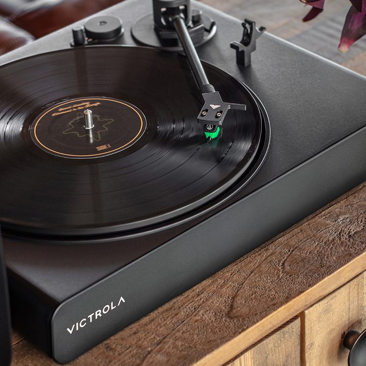 The Victrola Stream Onyx Sonos-ready turntable on a wooden cabinet.