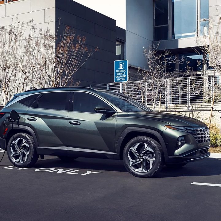 A 2022 Hyundai Tucson PHEV plugged in at a public charging station.