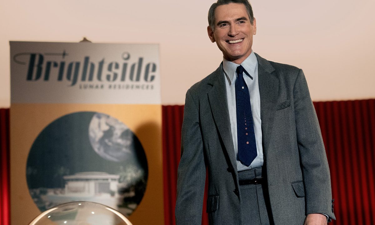Billy Crudup stands near a Brightside poster in Hello Tomorrow.