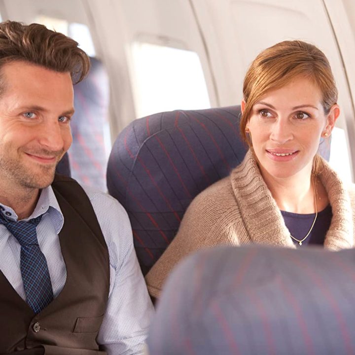 Two people sit next to each other on an airplane.