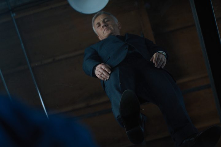 Christoph Waltz looks down through a glass floor in The Consultant.