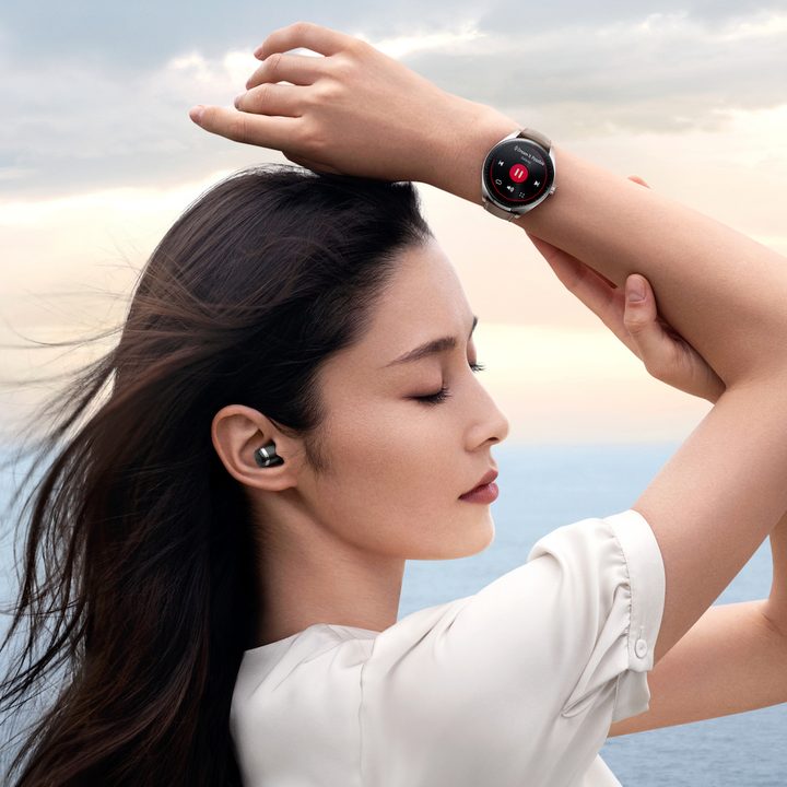 Person wearing the Huawei Watch Buds smartwatch and earbuds.