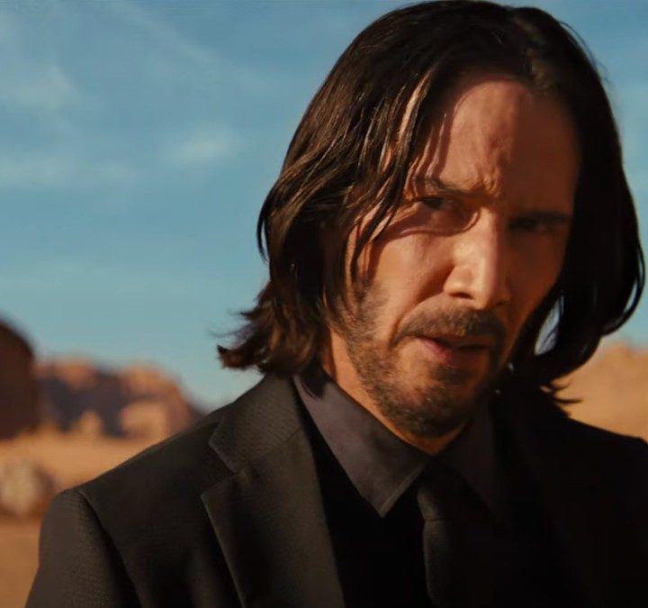 Keanu Reeves stands and stares in the middle of the desert in John Wick: Chapter 4.