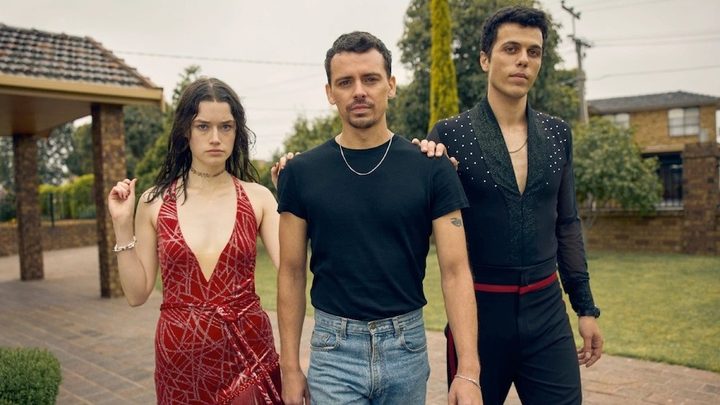 Two men and a woman stands in a yard in Of an Age.