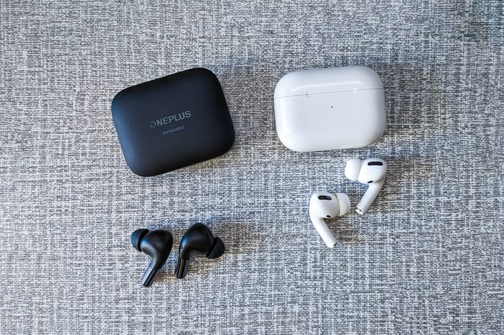 OnePlus Buds Pro 2 in black and AirPods Pro first generation in in white on a white and gray table top.
