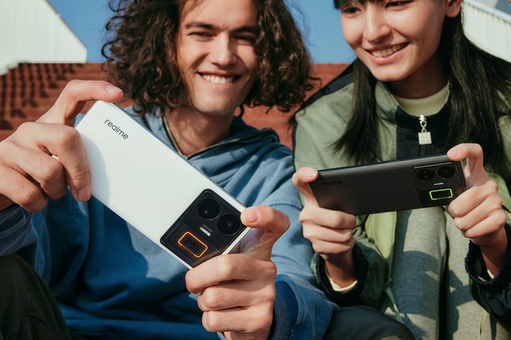 People holding the Realme GT3 smartphone.