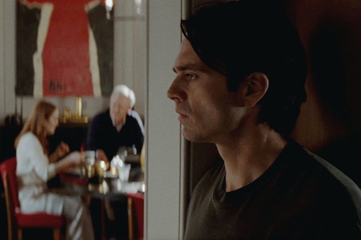 Sebastian Stan stands at the edge of a doorway in Sharper.