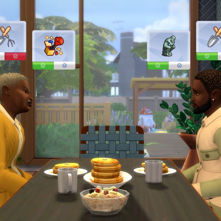 An elder Sim and an adult Sim sit across a dining table from each other. They have different likes and dislikes displayed above their head.