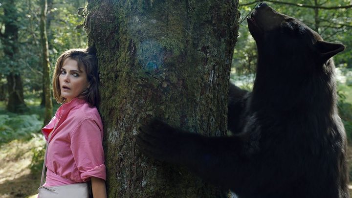 A woman hides from a bear in Cocaine Bear.