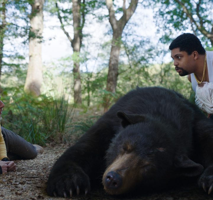 Aaron Holliday and O'Shea Jackson Jr. stare at each other over the body of a bear collapsed between them.